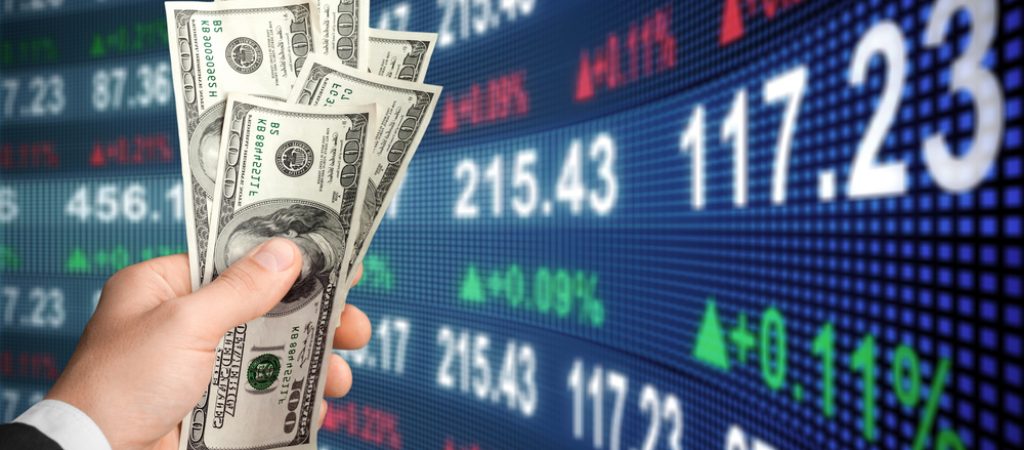 American,Dollar,In,Man's,Hand,And,Stock,Market,Screen,,Money